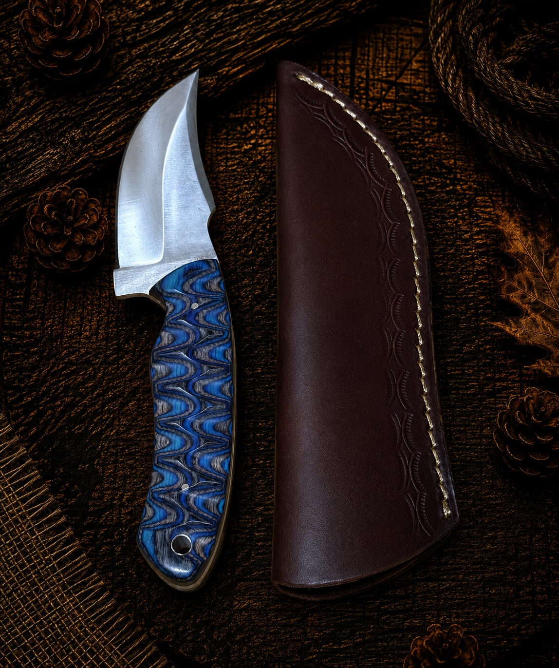 Damascus fixed blade knife with pink resin and dark wood handle and embossed leather sheath