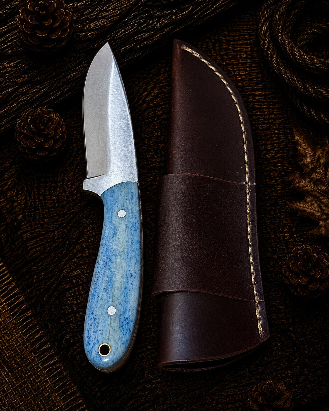 Damascus fixed blade knife with orange and green layered wood handle and embossed leather sheath