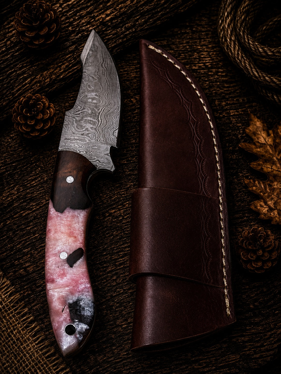 Damascus fixed blade knife with crimson and pearl swirl resin handle and embossed leather sheath