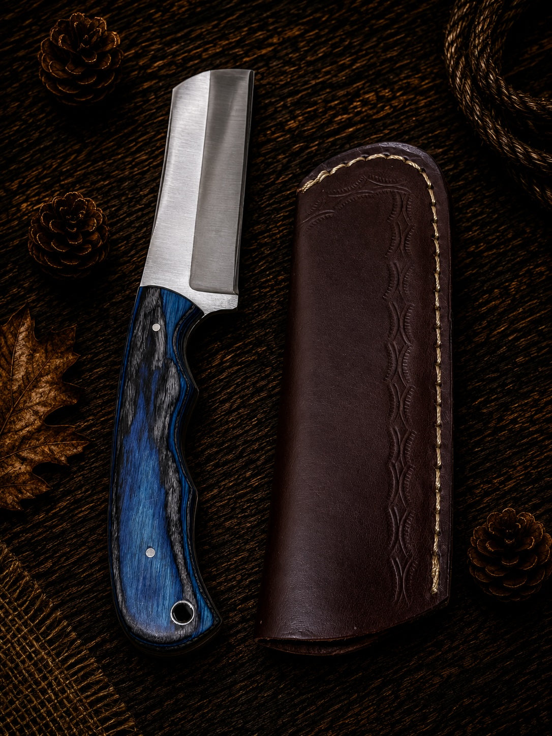 Compact fixed blade skinner knife with red and black swirl resin handle and embossed leather sheath